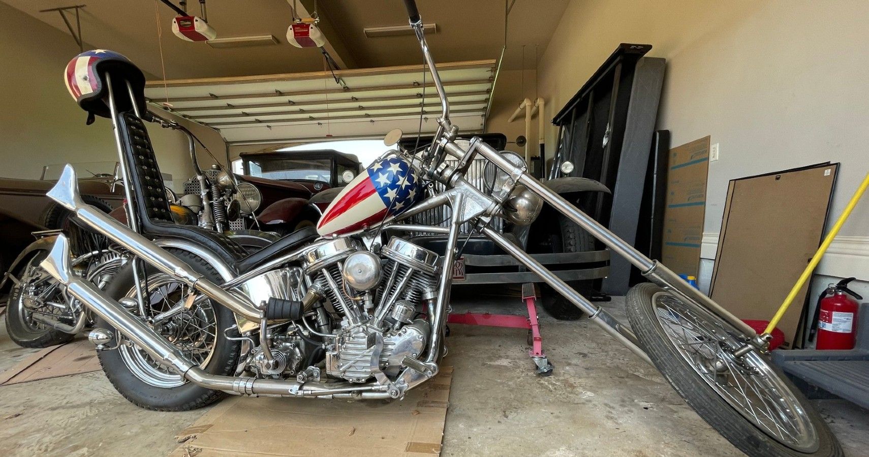 One of the Captain America choppers from Easy Rider parked in a garage.