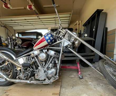 One of the Captain America choppers from Easy Rider parked in a garage.