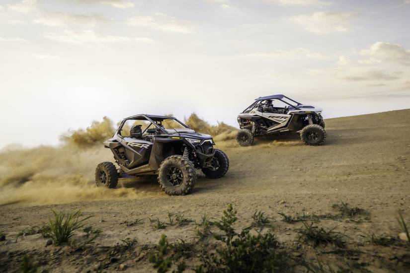 Two 2022 Polaris ATVs racing in the dirt