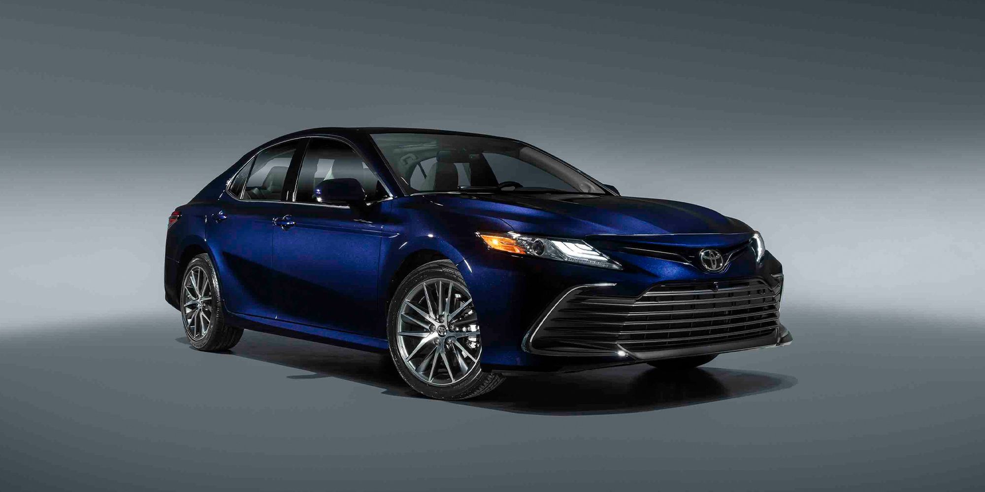Front 3/4 view of a blue Camry, grey background