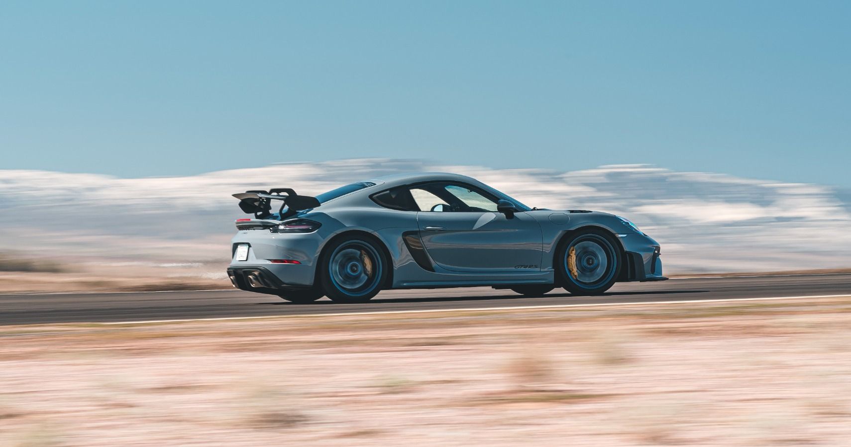 The Porsche Cayman GT4 RS accelerates on the road. 